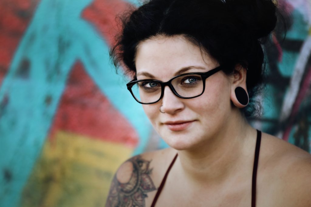 tattooed woman wearing glasses